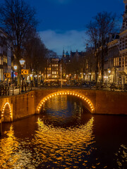 Fototapeta na wymiar Bridges illuminated at night on the Keizersgracht canal in Amsterdam in winter