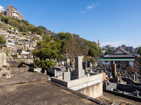 Buddhist cemetery at Nishizaka hill with roofs of Shorinzan Honrenji and Kannon statue of Fukusaiji temple at the distance - Nagasaki, Japan