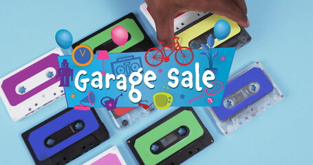 Image of garage sale text over hand holding tape on blue background