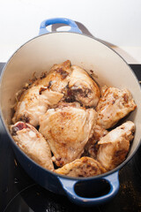 Fried chicken thighs in a blue casserole dish