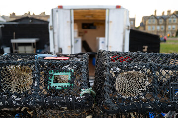 Shallow focus of lobster pots seen outside a refrigeration unit, used as a fresh fish shop located...