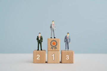 Miniature  businessmen  standing on wooden cube blocks with 1, 2, 3 number and guarantee symbol