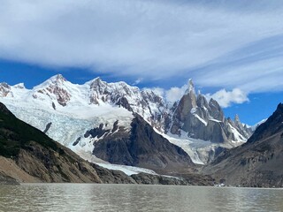 Snow and ice cover the Cerro Torre mountains reflecting on a lake