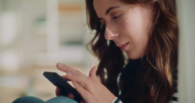 Young female brunette browsing internet on smartphone