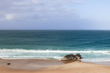 A serene view of Durness Beach, showcasing the tranquil blue waters of the Atlantic meeting the...