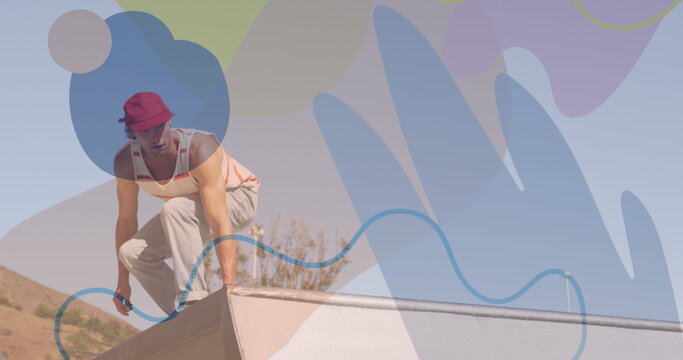 Image of colourful shapes over caucasian man skateboarding - Powered by Adobe