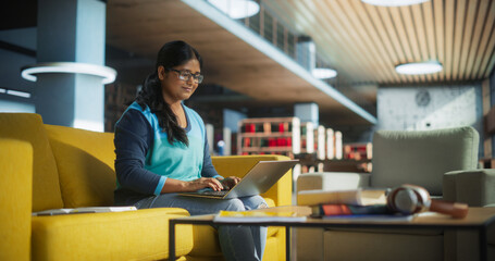 Smart Indian Female Student in Glasses Working on Software Development Assignment in a Quiet Public...