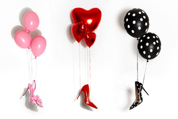 Sexy high heels hang on colorful balloons on a white background.