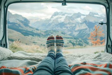 Woman inside motorhome on vacation with her feet wearing socks. Spectacular landscape ahead. Feet view. 