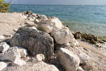 a pile of stones on the shore of the beach that are washed by the sea water 