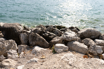 a pile of stones on the shore of the beach that are washed by the sea water 