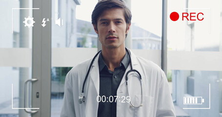 Portrait of smiling young male doctor displayed on a digital camera in 4k record mode.