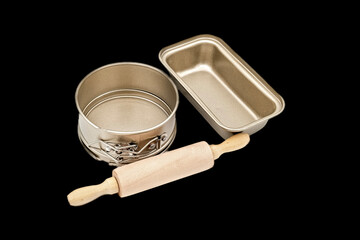 Baking forms for cake with Wooden rolling pin on black background