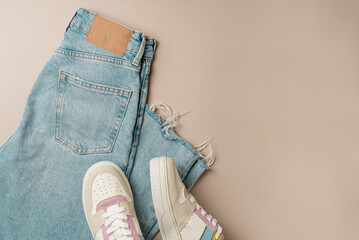 Women's jeans and sneakers on beige background