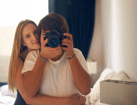 Camera, photography and couple on a bed with love, care and bonding in their home together. Lens, picture and portrait of people hug in a bedroom with support, security vacation memory in their house