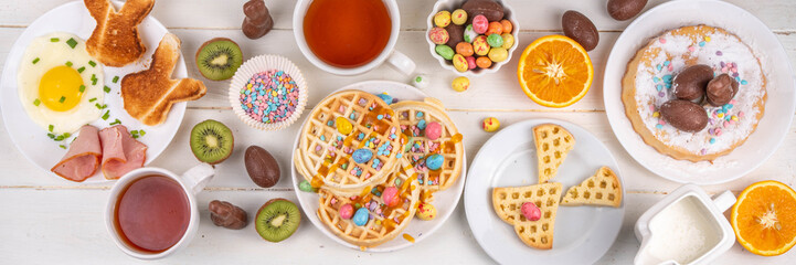 Easter breakfast or brunch. Cute creative decor portion of soft sweet belgian waffles with Easter chocolate eggs, sugar sprinkles and jam or syrup drizzles - Powered by Adobe