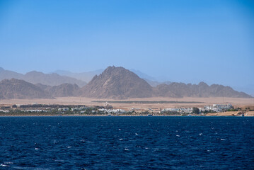 Coastline of Red Sea. Parasols are placed on sandy shore along bay coast. Sharm el-Sheikh, Egypt, April 20, 2008