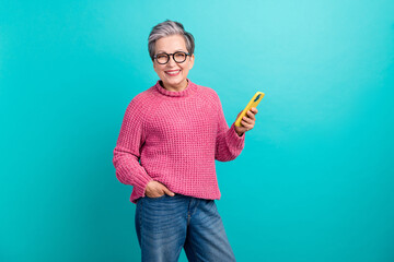Portrait of confident woman wear pink pullover in eyewear holding smartphone hand in pocket...