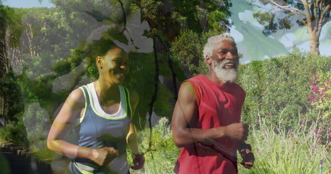 Image of leaves over african american couple running, slow motion