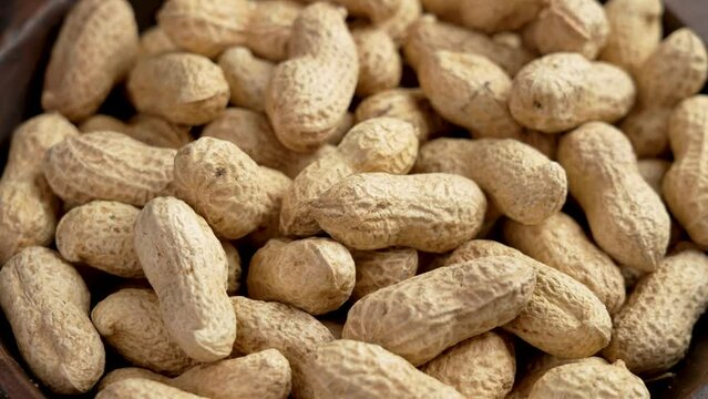 Peanuts pods in shell. Full rustic bowl of crunchy nutritious ingredient. Rotation