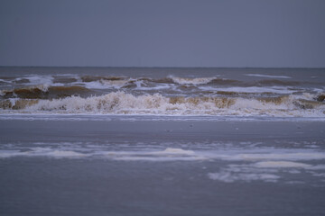 The North Sea swirling in cloudy weather. Big waves due to strong wind. Dangerous weather conditions