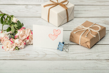 Roses, pencil drawing of hearts and gift boxes on a wooden background. Do-it-yourself congratulations on Mother's Day, Valentine's Day, Birthday and Women's Day.