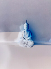 white candle made of soy wax with the image of the god Buddha