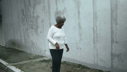 Elderly South American black woman arrives home from sidewalk street, opens residence front door...