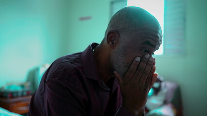 Close-Up Portrait of an African American Elder Coping with Emotional Distress in a Dimly Lit Room,...