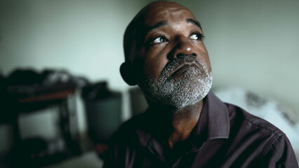 Desperate African American Senior Man in Deep Thought, Struggling with Sadness and depression in Moody Bedroom, Dramatic Portrait gazing at window feeling quiet despair