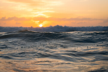 View of ocean water surface with warm sunrise light.
