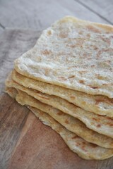 Freshly baked Moroccan flaky pancakes on a wooden table. 
