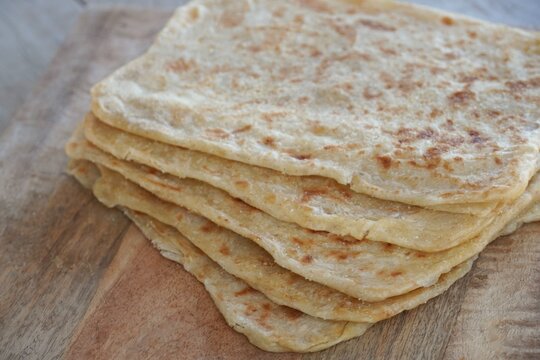 Freshly baked Moroccan crepes on a wooden table.