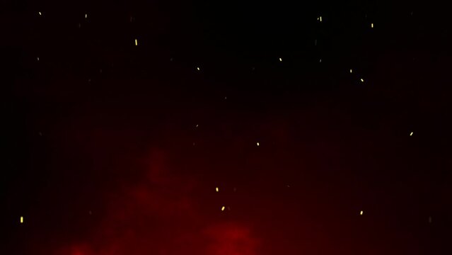 Fire embers particles over red smoke on black background. Abstract dark glitter fire particles lights. Bonfire in motion blur.
