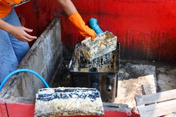 Grease traps from dirty debris being cleaned with a scoop are discarded. How to treat water with a...