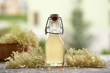 A bottle of homemade elderberry flower syrup outdoors