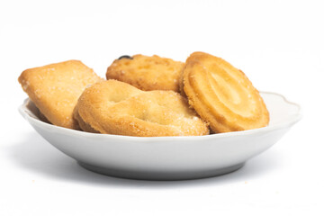 Group of assorted of danish butter cookies in a small white plate isolated on white background...