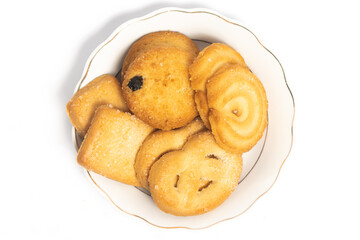 Group of assorted of danish butter cookies in a small white plate top view isolated on white background clipping path