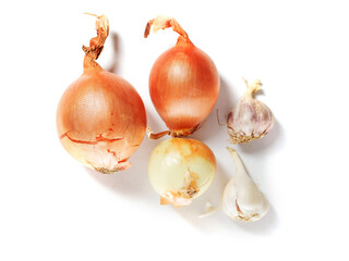 Brown color organic onion and garlic cloves on white surface. Worldwide popular product and food ingredient. Garden vegetable.