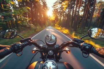 A rider's perspective of motorcycle handlebars on a road lined with trees during a beautiful sunset - obrazy, fototapety, plakaty