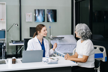 Portrait of female doctor explaining diagnosis to her patient. Doctor Meeting With Patient In Exam Room. A medical practitioner reassuring a patient .