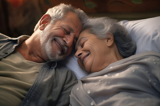 An elderly man and woman, a couple in love, laying comfortably in bed together