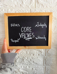 Core values written on black chalkboard . Ethics , integrity ,Respect and Honesty 