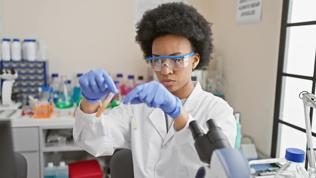 A focused female scientist conducts experiments in the laboratory, pipetting into test tubes.