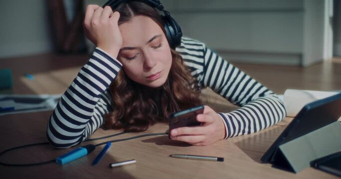 Woman browsing on smartphone while lying and listening to music