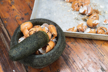 egg shell being crush with pestle and mortar