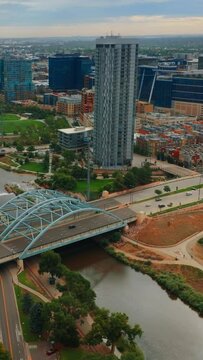 South Platte River flowing through gorgeous Denver, Colorado, USA. Panorama of the city on gloomy daytime from aerial view. Vertical video.