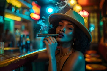 Foto op geborsteld aluminium Havana Pretty young women smokes a cigar: An exotic young Cuban woman sits at a bar in Havana, Cuba and smokes a Cuban cigar and enjoy the relaxed nightlife in havana
