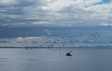 kayakers on Lake Ometepe and birds flying by. Nicaragua