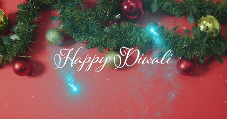 Image of happy diwali text over christmas decorations